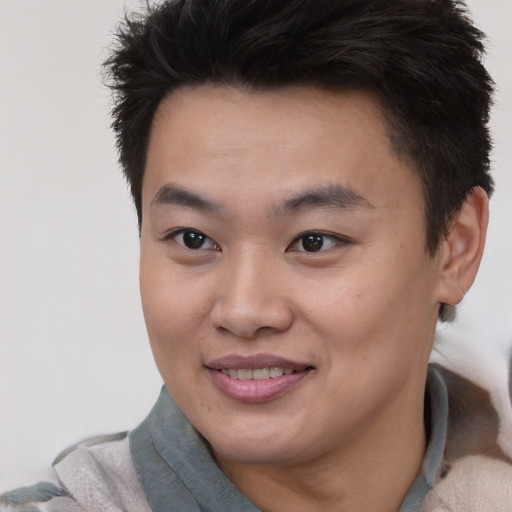 Joyful asian young-adult male with short  brown hair and brown eyes