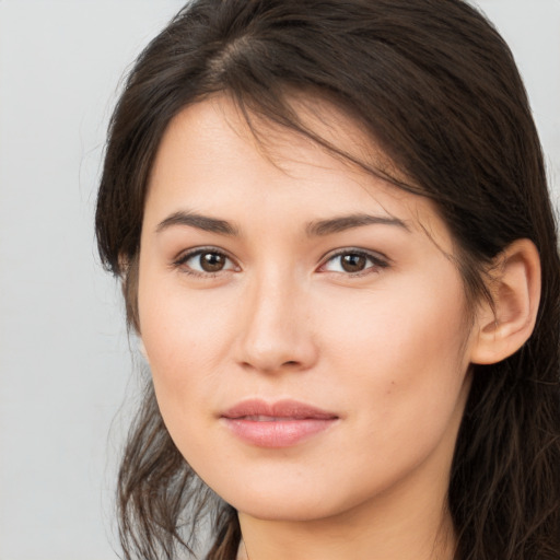 Joyful white young-adult female with long  brown hair and brown eyes