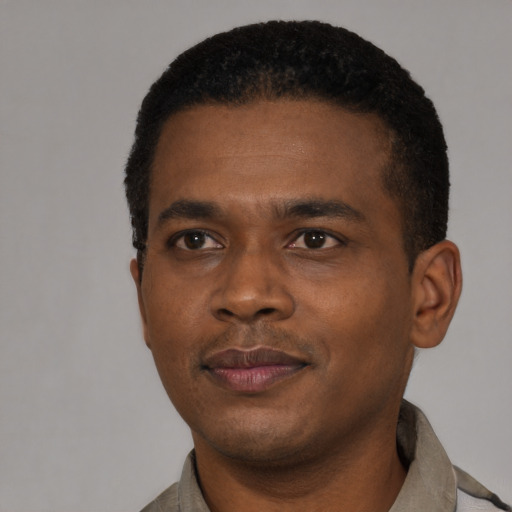 Joyful black young-adult male with short  black hair and brown eyes