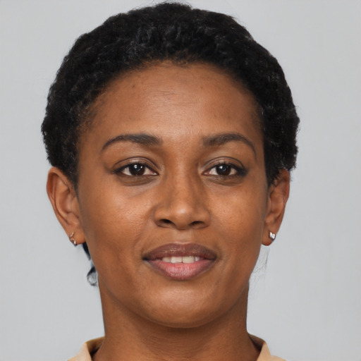 Joyful black young-adult female with short  brown hair and brown eyes