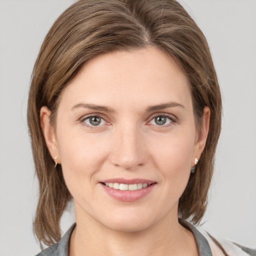 Joyful white young-adult female with medium  brown hair and grey eyes