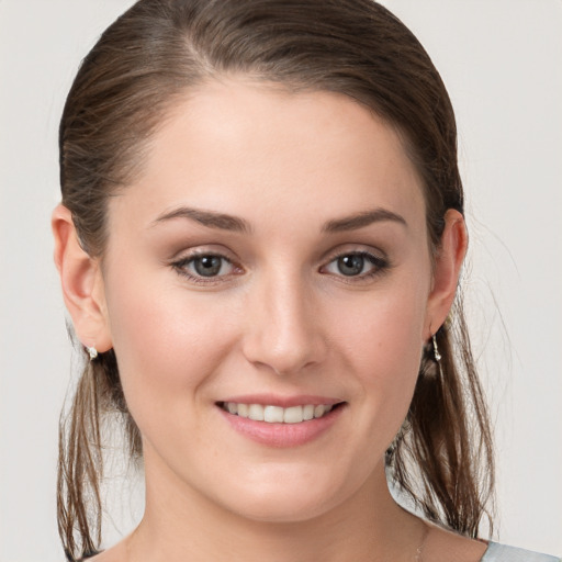 Joyful white young-adult female with medium  brown hair and grey eyes