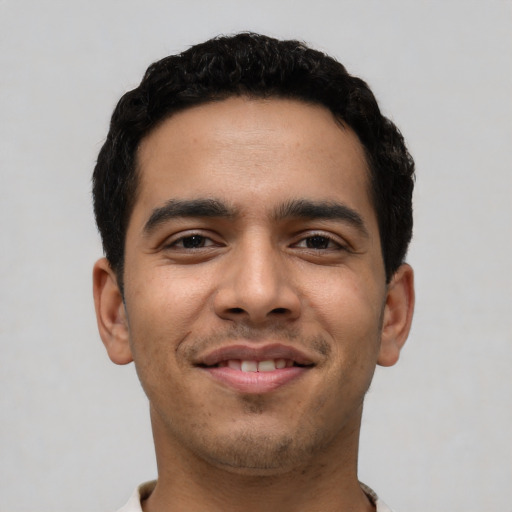 Joyful latino young-adult male with short  black hair and brown eyes