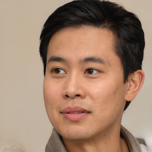 Joyful asian young-adult male with short  brown hair and brown eyes