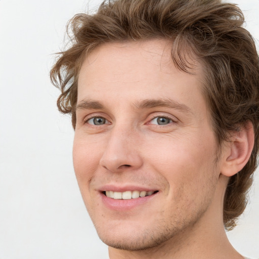 Joyful white young-adult male with short  brown hair and green eyes