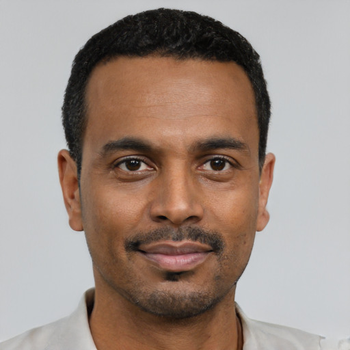 Joyful black young-adult male with short  black hair and brown eyes