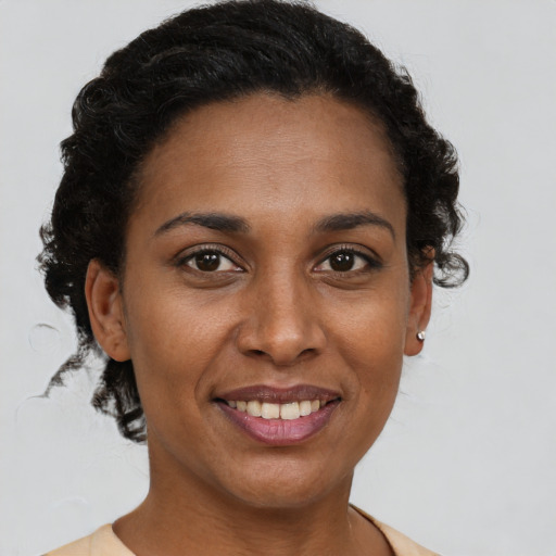 Joyful black young-adult female with short  brown hair and brown eyes