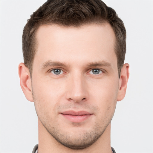 Joyful white young-adult male with short  brown hair and grey eyes