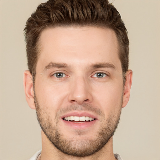 Joyful white young-adult male with short  brown hair and grey eyes