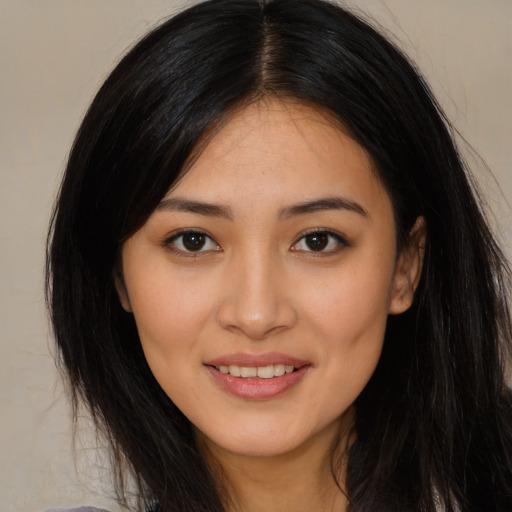 Joyful latino young-adult female with long  brown hair and brown eyes