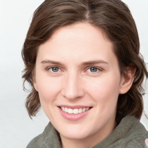 Joyful white young-adult female with medium  brown hair and blue eyes