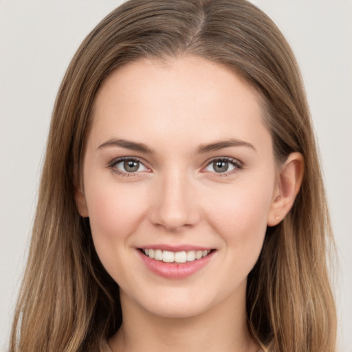 Joyful white young-adult female with long  brown hair and grey eyes