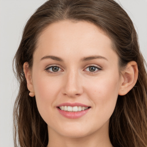 Joyful white young-adult female with long  brown hair and grey eyes