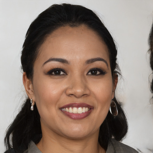 Joyful latino young-adult female with long  black hair and brown eyes