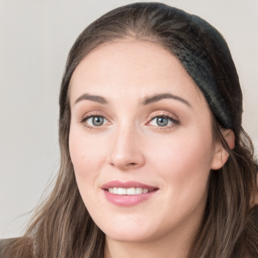 Joyful white young-adult female with long  brown hair and grey eyes