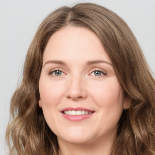 Joyful white young-adult female with long  brown hair and green eyes