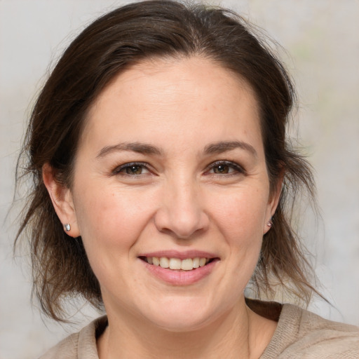 Joyful white adult female with medium  brown hair and brown eyes