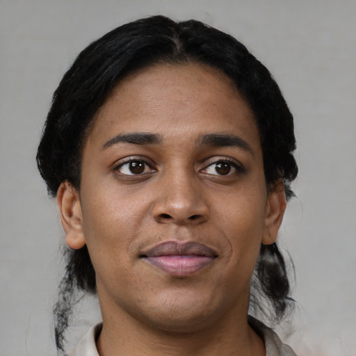 Joyful black young-adult female with short  black hair and brown eyes