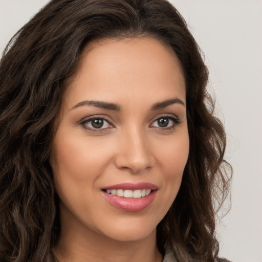 Joyful white young-adult female with long  brown hair and brown eyes