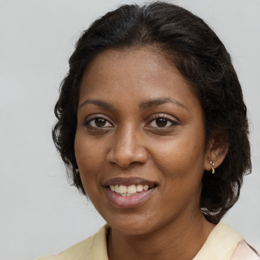 Joyful black young-adult female with long  brown hair and brown eyes