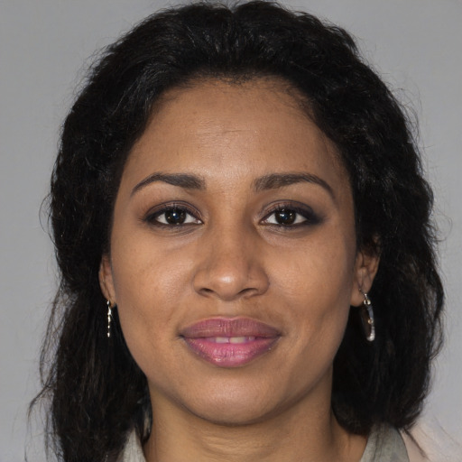 Joyful black adult female with long  brown hair and brown eyes