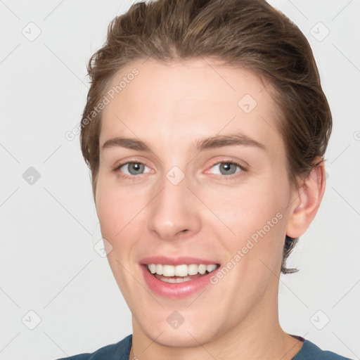 Joyful white young-adult female with medium  brown hair and grey eyes