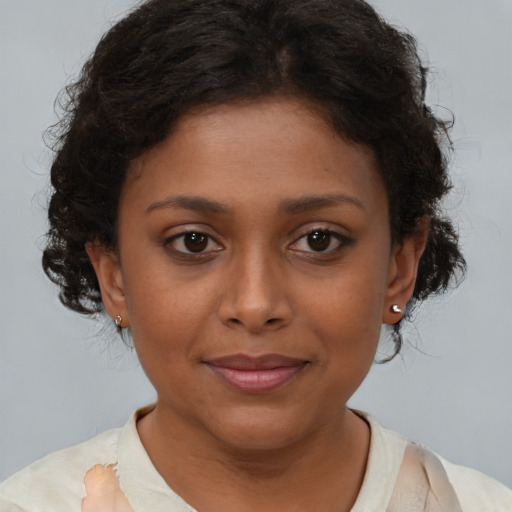 Joyful black young-adult female with short  brown hair and brown eyes