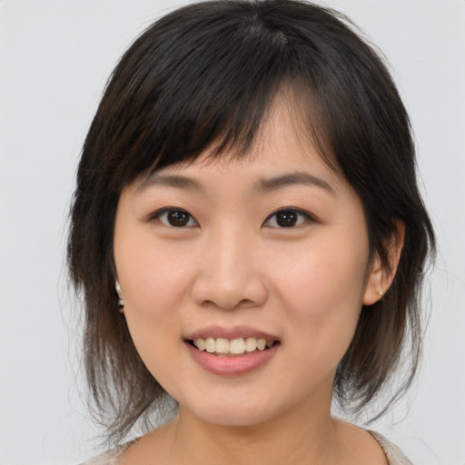 Joyful asian young-adult female with medium  brown hair and brown eyes