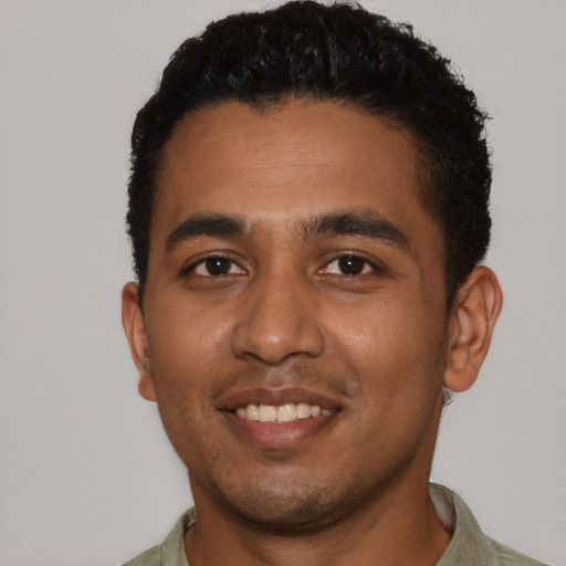 Joyful black young-adult male with short  brown hair and brown eyes