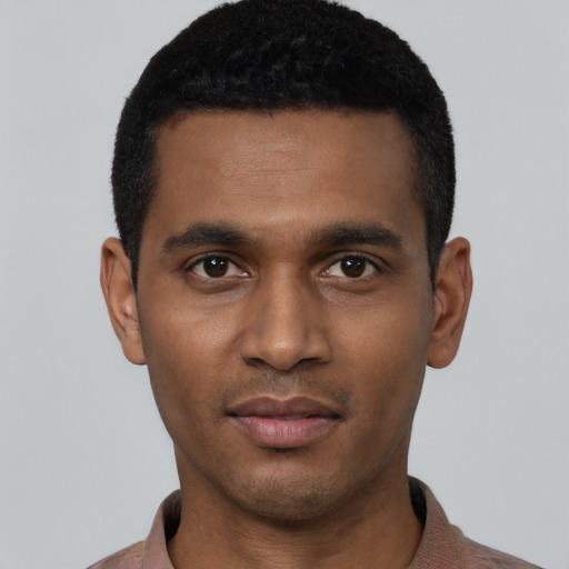 Joyful black young-adult male with short  black hair and brown eyes