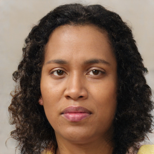 Joyful black young-adult female with medium  brown hair and brown eyes