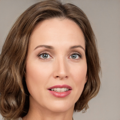 Joyful white young-adult female with medium  brown hair and green eyes