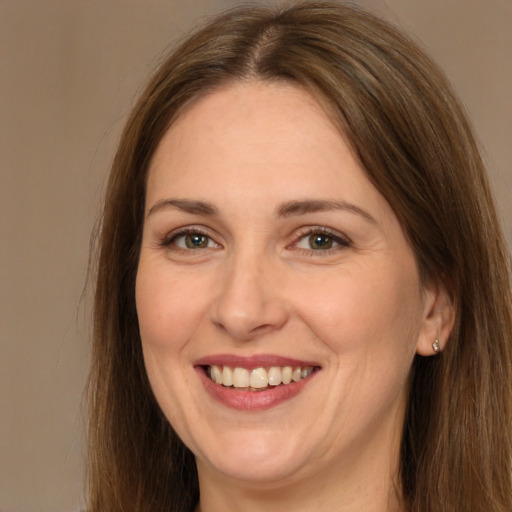 Joyful white adult female with long  brown hair and brown eyes