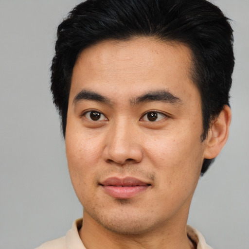 Joyful asian young-adult male with short  brown hair and brown eyes