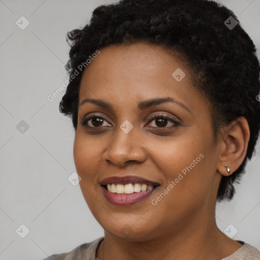 Joyful black young-adult female with short  black hair and brown eyes