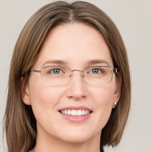 Joyful white adult female with long  brown hair and grey eyes