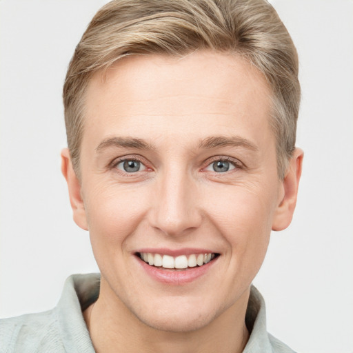 Joyful white young-adult female with short  brown hair and blue eyes