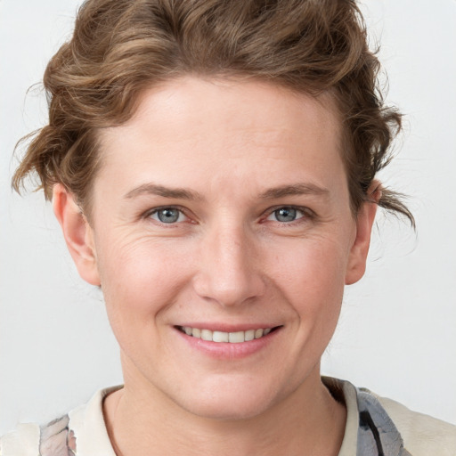 Joyful white young-adult female with short  brown hair and blue eyes