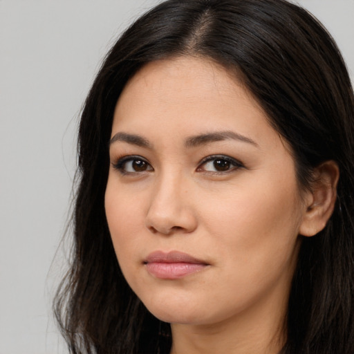 Joyful asian young-adult female with long  brown hair and brown eyes