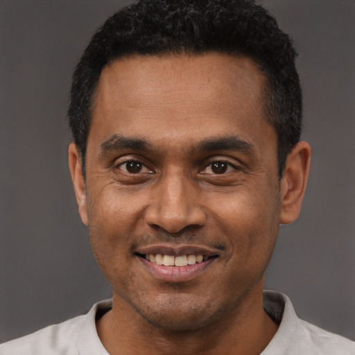 Joyful latino adult male with short  black hair and brown eyes