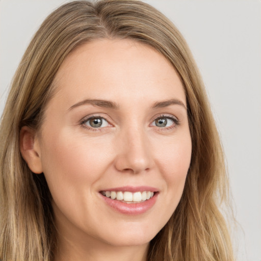 Joyful white young-adult female with long  brown hair and green eyes