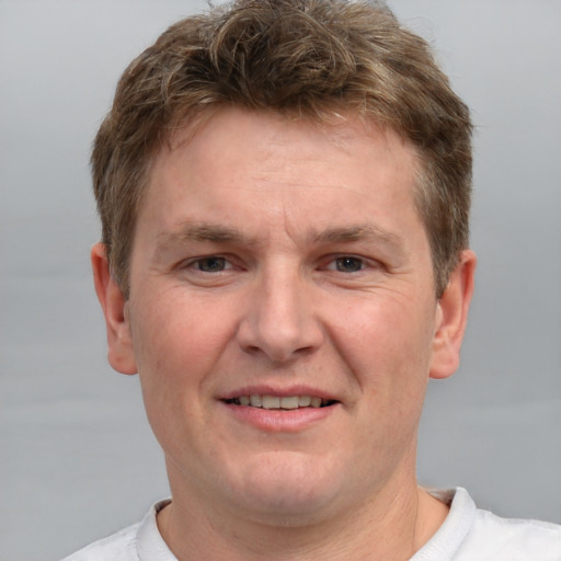 Joyful white adult male with short  brown hair and grey eyes