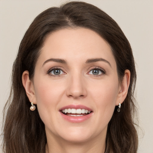 Joyful white young-adult female with long  brown hair and grey eyes