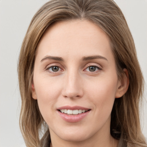 Joyful white young-adult female with long  brown hair and grey eyes