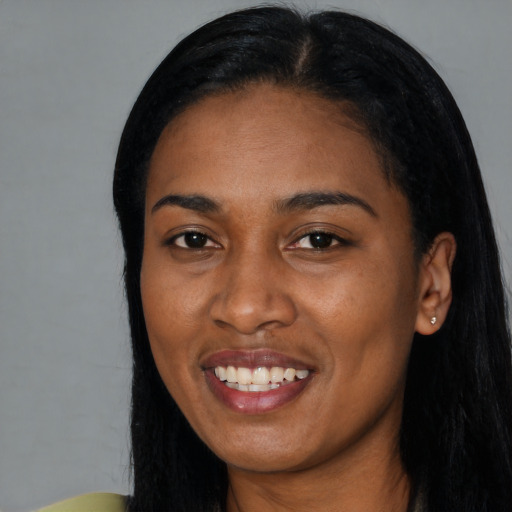 Joyful black young-adult female with long  black hair and brown eyes
