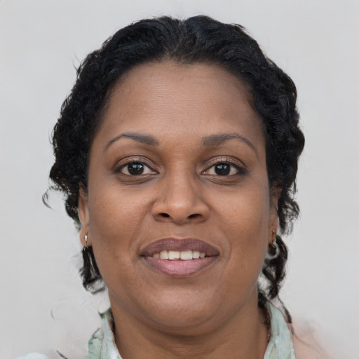 Joyful black adult female with long  brown hair and brown eyes