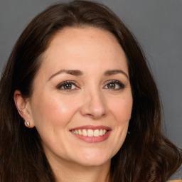 Joyful white adult female with long  brown hair and brown eyes