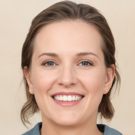 Joyful white young-adult female with medium  brown hair and grey eyes