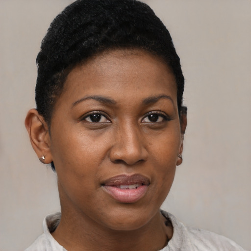 Joyful black young-adult female with short  black hair and brown eyes