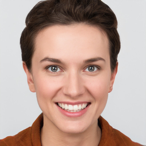 Joyful white young-adult female with short  brown hair and grey eyes